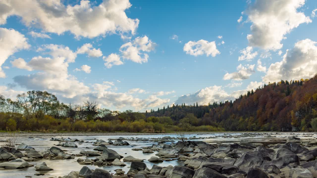 banco de piedra contra árboles coloridos que crecen en las colinas en otoño