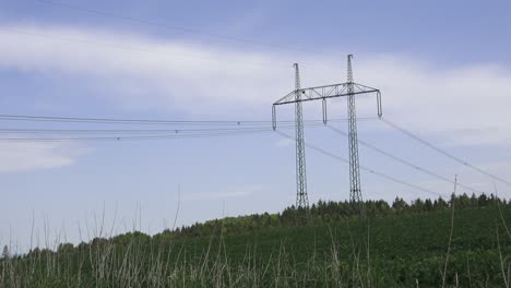 large view on the powerlines on the field. high voltage post or high voltage tower in field.