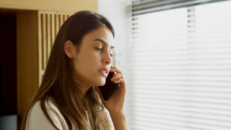 woman talking on mobile phone in living room 4k