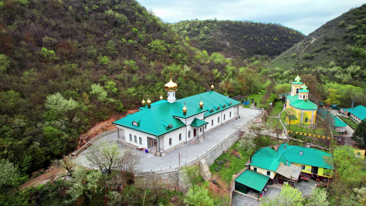 Aerial drone view of Saharna Monastery, Moldova. Monastery with churches located in a valley covered with lush forest