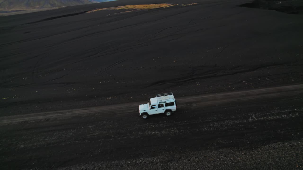 아이슬란드 풍경, 공중 무인 항공기 영상에서 검은 모래 지형을 통해 운전하는 흰색 랜드 로버