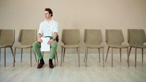 man sitting in a waiting room, waiting for his interview.