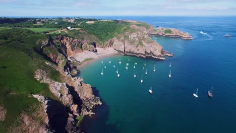 Imágenes-Aéreas-De-Drones-Estáticos-De-4k-De-Muchos-Veleros-Amarrados-En-Una-Playa-Fantástica-En-La-Isla-De-Sark,-Reino-Unido