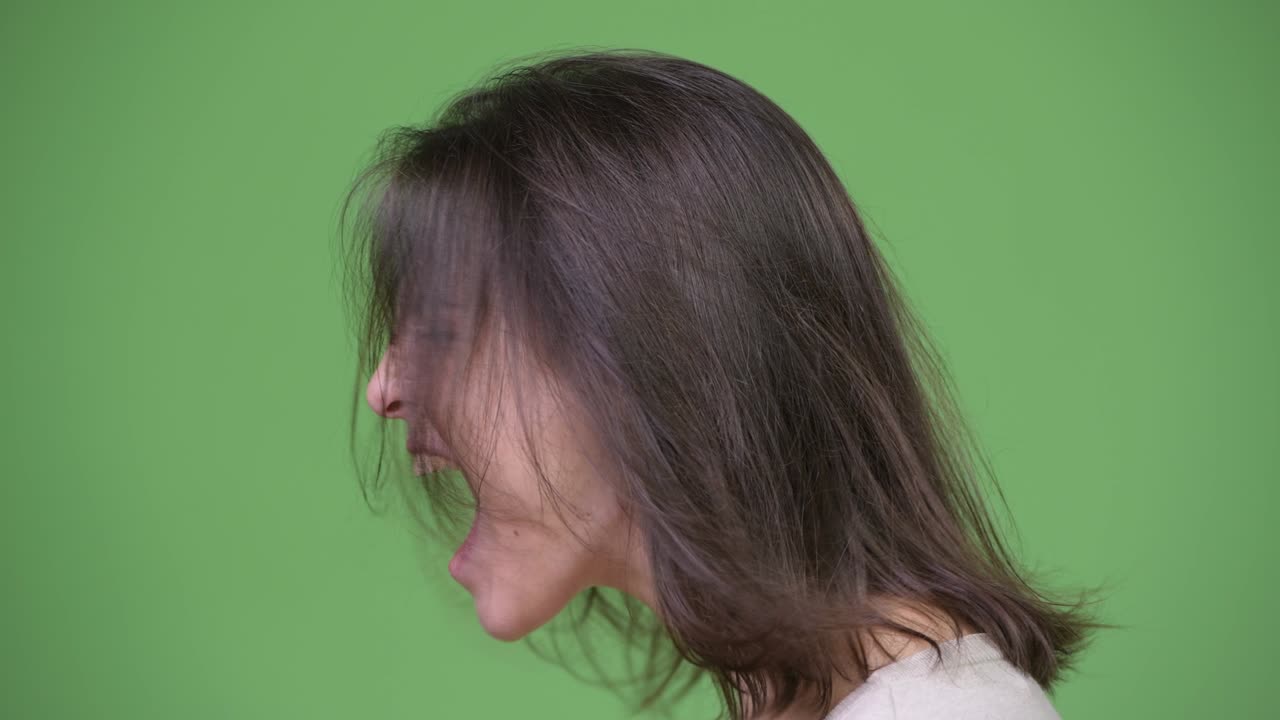 초록색 배경에 비명을 지르는 젊은 아름다운 여성의 프로필 뷰