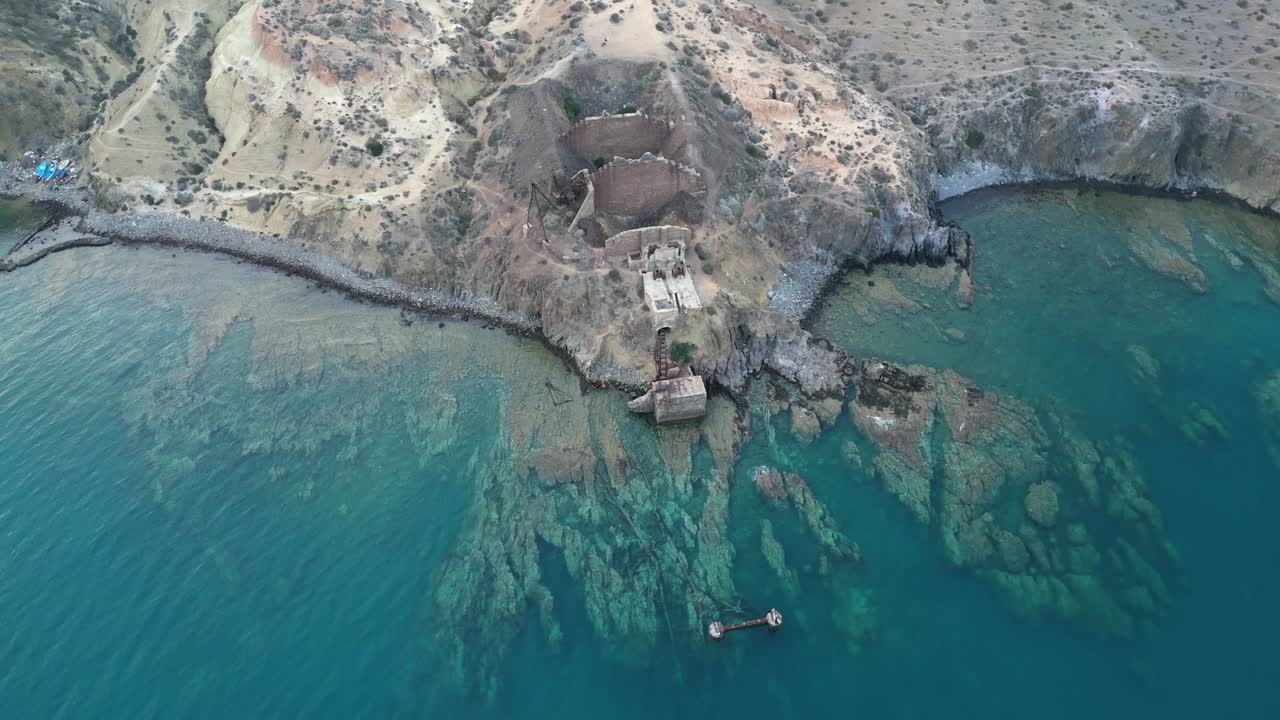 la perspectiva aérea revela la mina de hierro abandonada y el puerto deteriorado, ahora ruinas inquietantes junto al mar.