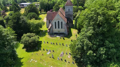 an upward-tilt-shot over a graveyard, tilting up towards st lawrence the martyr church in godmersham