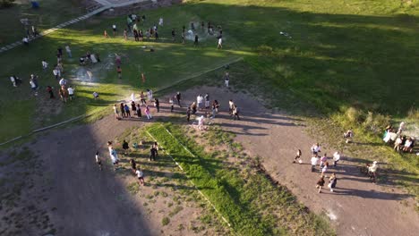 aerial orbiting shot of student celebrating graduation outdoors with friends and family