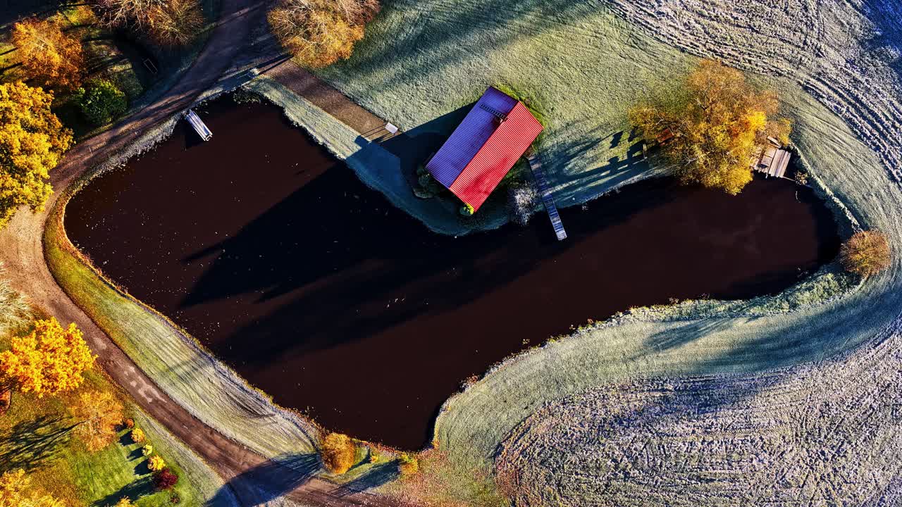 Ripresa aerea dall'alto di un drone di una casa vicino al limitare della foresta che mostra le ombre in movimento del time-lapse del tramonto sui colori autunnali