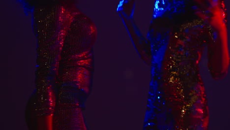 close up of two women in nightclub bar or disco dancing talking and having fun together 1