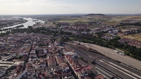 Vista-Aérea-Orbitando-La-Ciudad-De-Merida,-España,-Junto-Al-Río-Guadiana-Y-El-Horizonte-De-La-Provincia-De-Badajoz