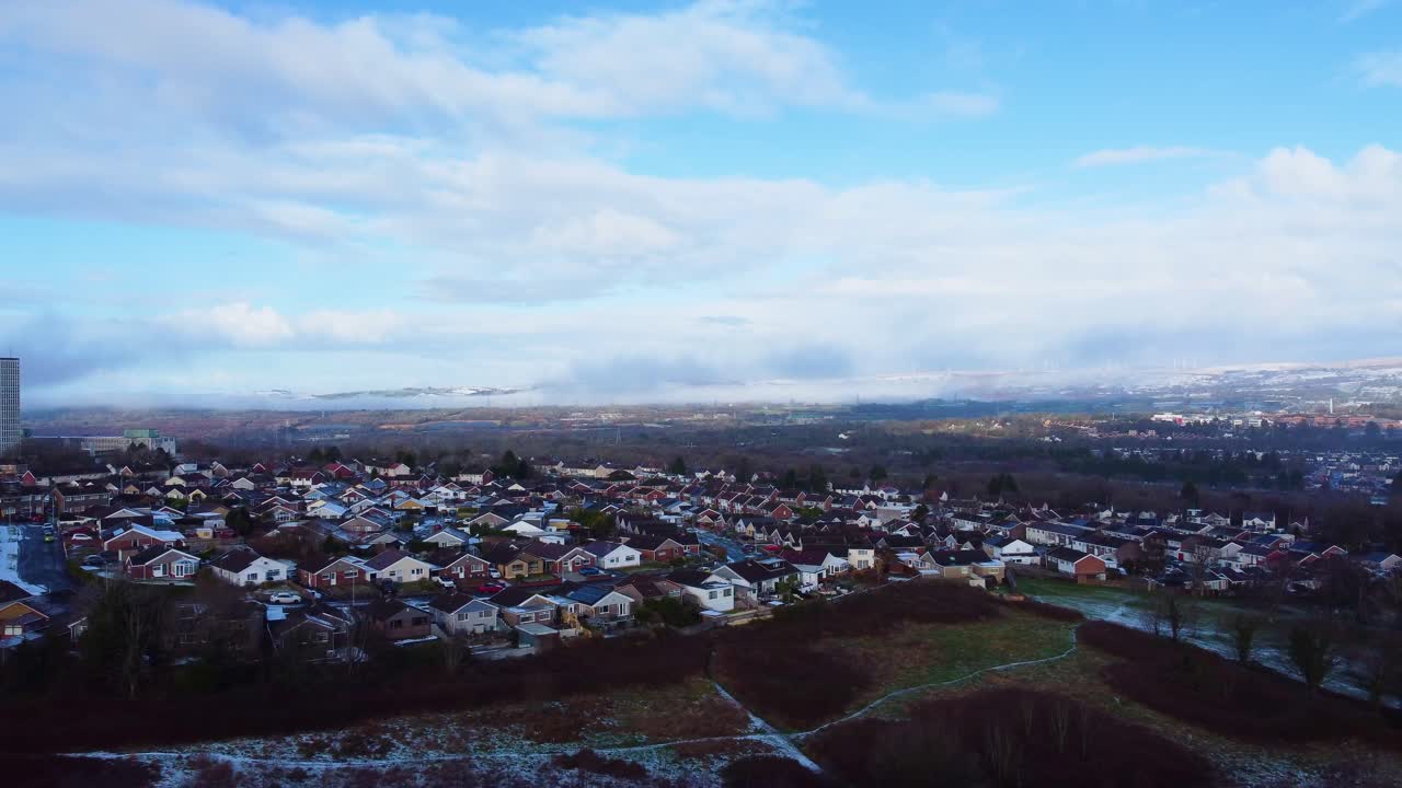 Bred dronevisning av en fritidspark om vinteren med forstadshus med snødekte åser og fjell i bakgrunnen. Perfekt for eiendomsmarkedsføring og etablering av eiendom.