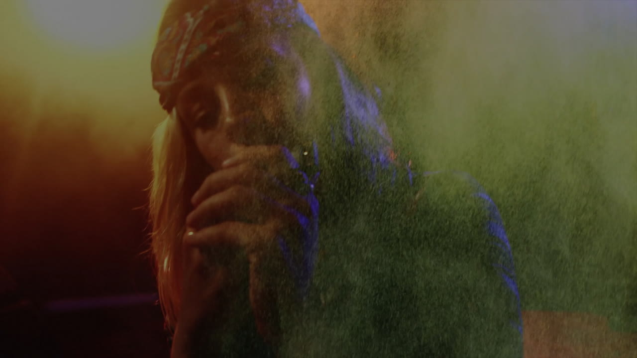 Woman singing into mic on music stage, featuring animated smoke particles and data chart overlays