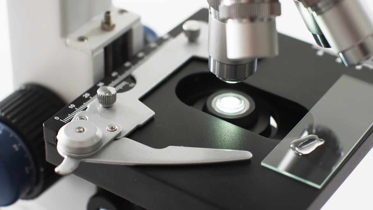 Video of close up of laboratory microscope with copy space on white background