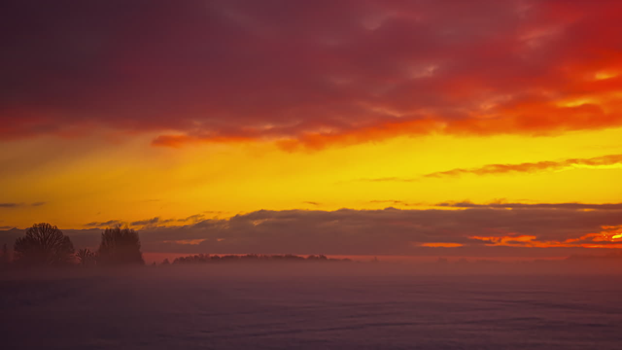 자연의 눈 덮인 겨울 풍경 위로 날아가는 주황색 하늘의 신비로운 구름, 시간 경과