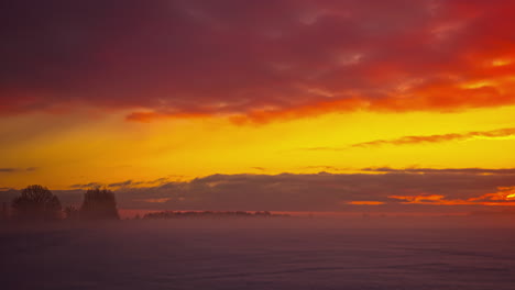 Mystische-Wolken-Am-Orangefarbenen-Himmel,-Die-über-Verschneite-Winterlandschaften-In-Der-Natur-Fliegen,-Zeitraffer