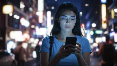woman using phone at night in a city