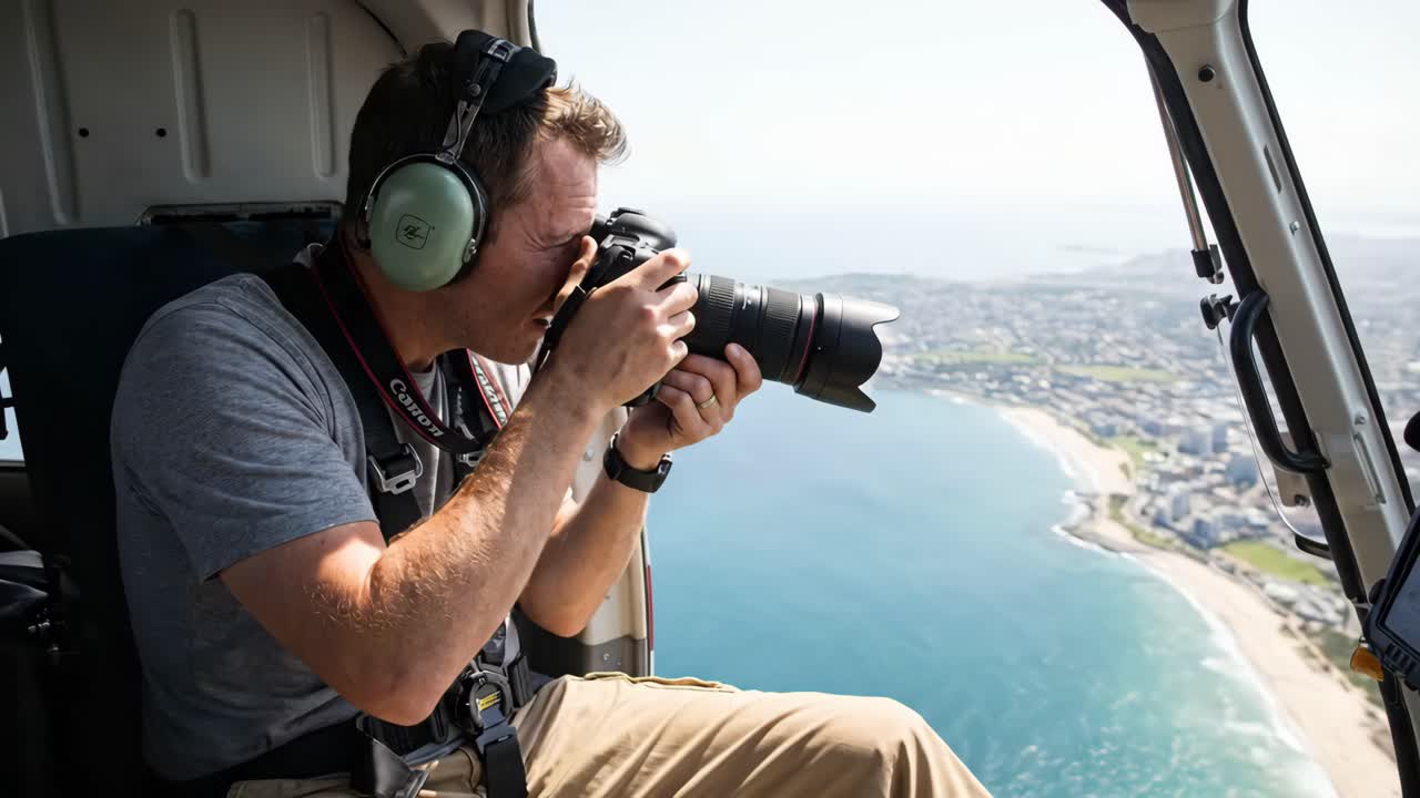 Mand, der tager luftfotos fra helikopter over kystby