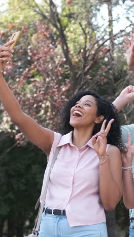 happy multiethnic friends taking self-portrait in city during sunny day