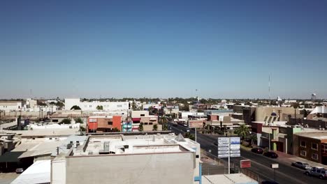 Vista-De-Un-Dron-Descendiendo-Muy-Lentamente-Mostrando-Algunos-Edificios