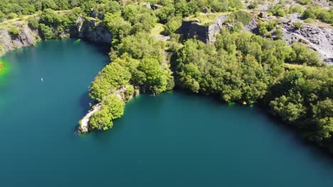 Vista-Aérea-Dorothea-Cantera-Minera-Inundada-Bosque-En-El-Valle-De-Snowdonia-Con-Un-Hermoso-Lago-Azul-Claro