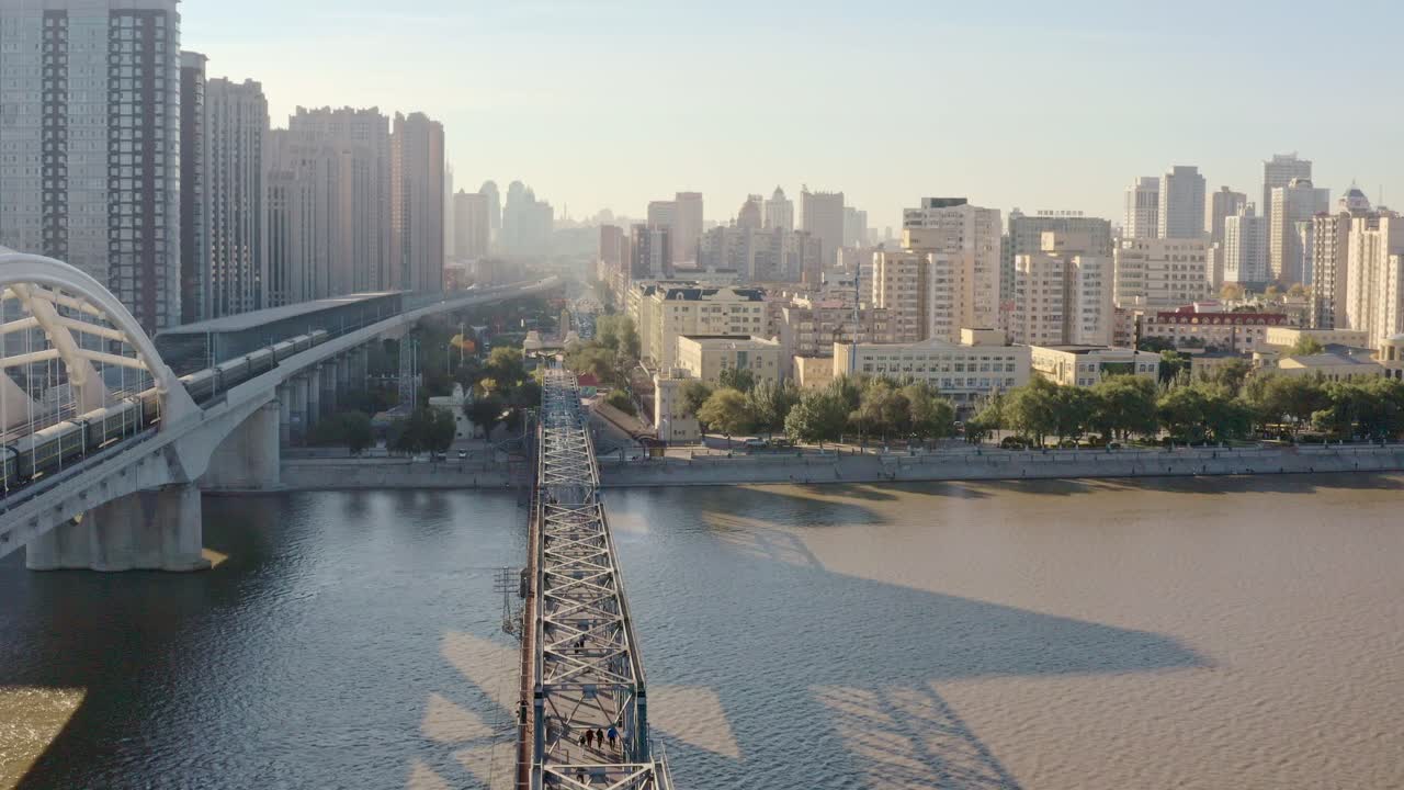 fly over- iconic songhua river railway bridges, single track historic steel bridge converted to walkway (zhongdong) museum next to modern arched railway bridge,