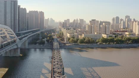 fly over- iconic songhua river railway bridges, single track historic steel bridge converted to walkway (zhongdong) museum next to modern arched railway bridge,