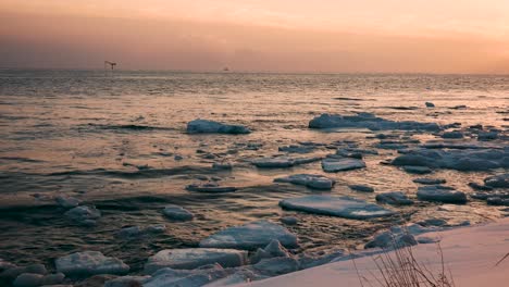scarlet sunset on the sea with ice floes in winter