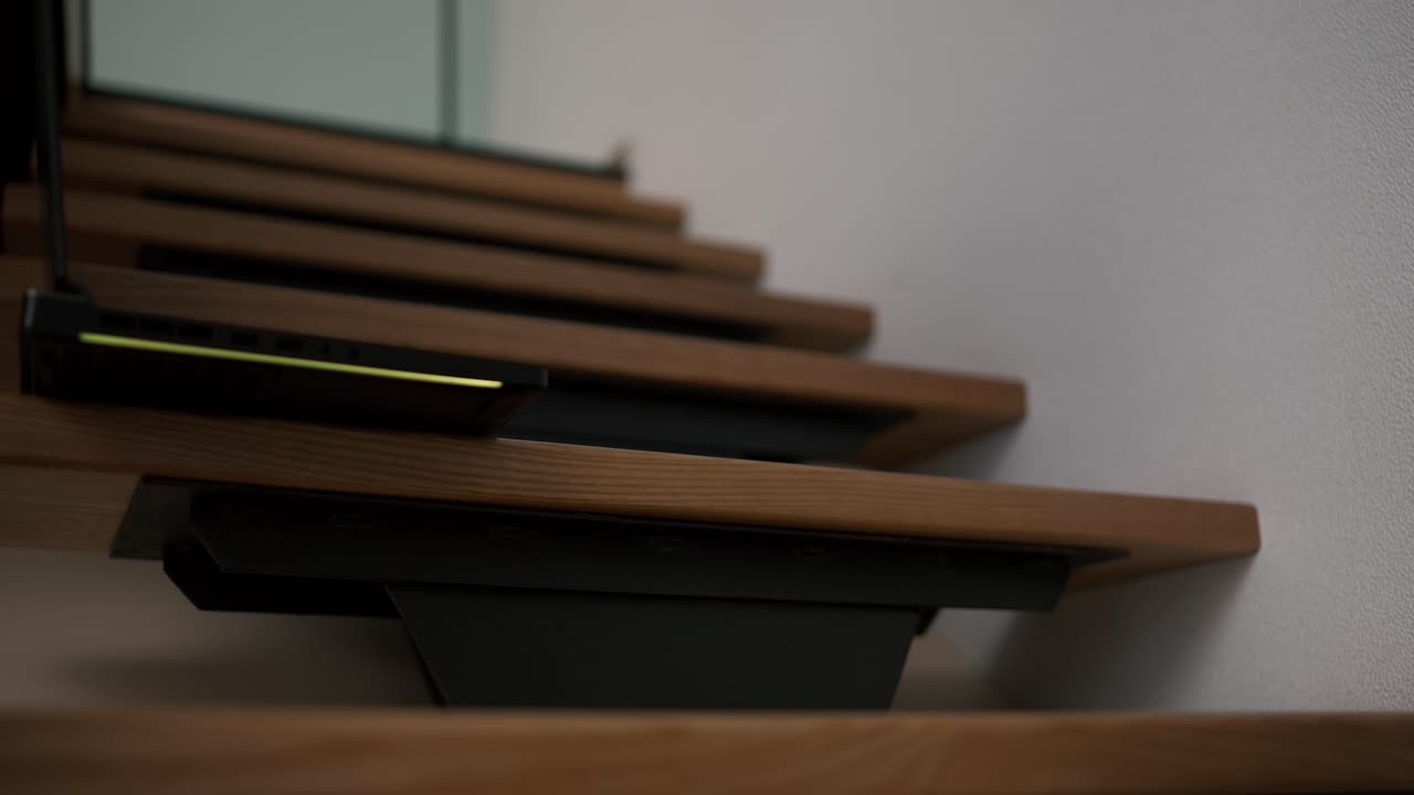 hombre irreconocible tomar el cierre de su computadora portátil y lo toma de las escaleras de la casa