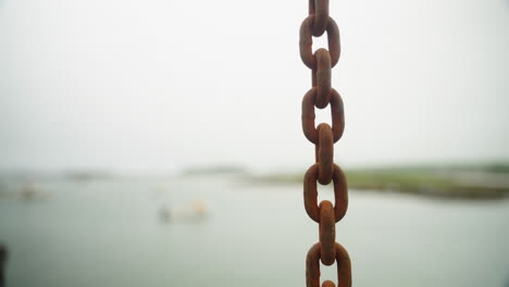 detail shot of chain hanging from fisherman's lift at fish dock pier 4k 60p