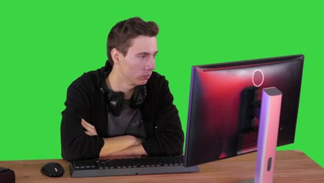 young man gamer watching stream game on a green screen, chroma key