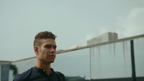 well-dressed entrepreneur businessman portrait of a young attractive trendy man wallking on a sunny morning day with a modern urban city background in slow motion