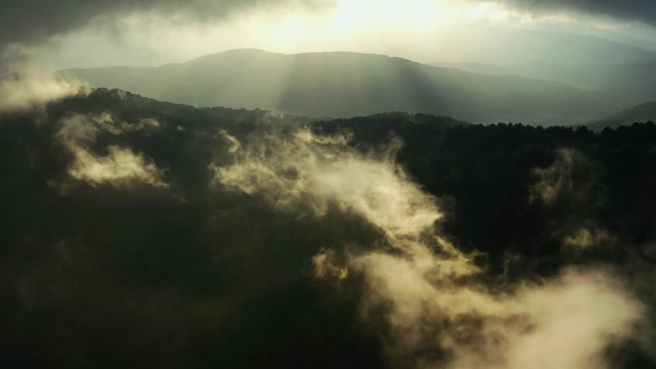 Drone flying above the mountains with clouds, in slow motion