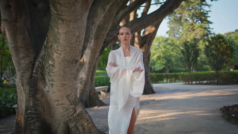 relaxed woman strolling park summer day. romantic girl walking on trees alley