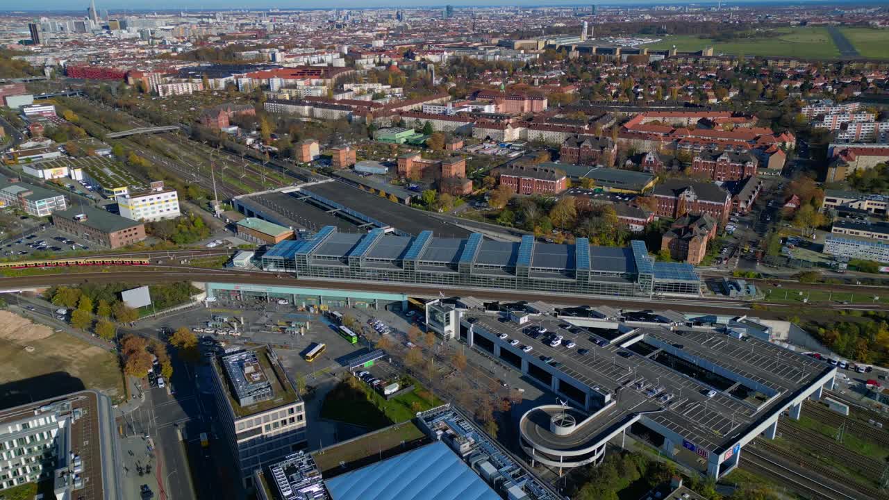 Berlin cityscape with a modern train station South Cross and extensive railway lines under a clear sky. Nice aerial view flight circle drone footage
