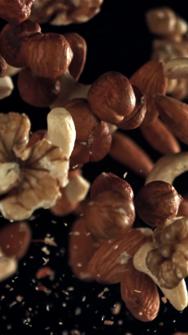 Assorted Nuts Floating in Slow Motion on a Black Background
