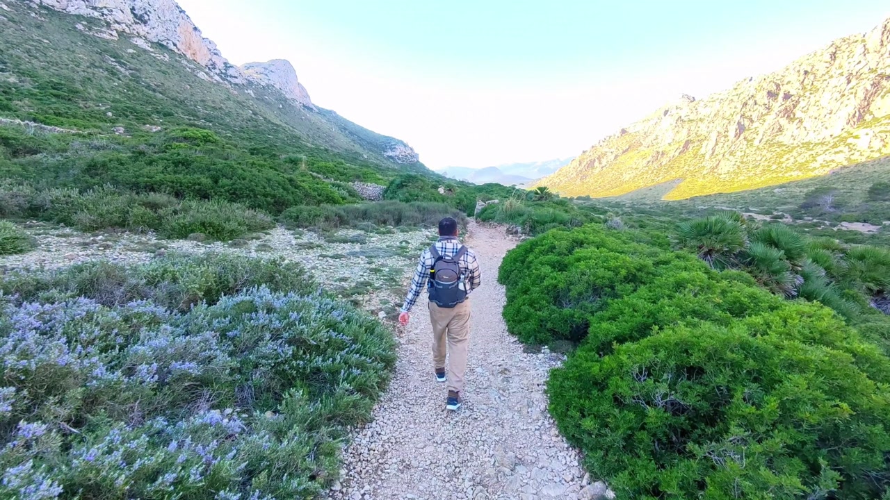 Man Hiking on Scenic Mountain Trail Towards Cala Boquer in Mallorca