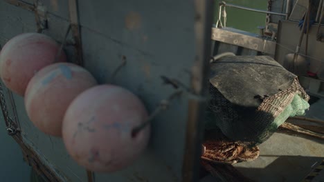 Slow-motion-reveal-shot-of-the-deck-of-a-fishing-boat-with-bets,-ropes-and-other-tools