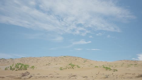 massive sand dunes occupying one-third of the image, panoramic landscape with blue sky and clouds