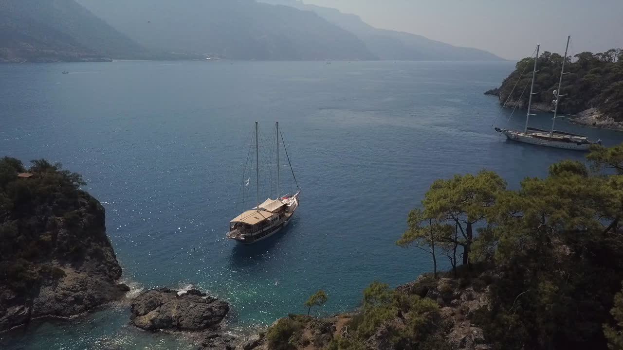 Aerial flight to tall tour ship moored in clear Mediterranean, Turkey