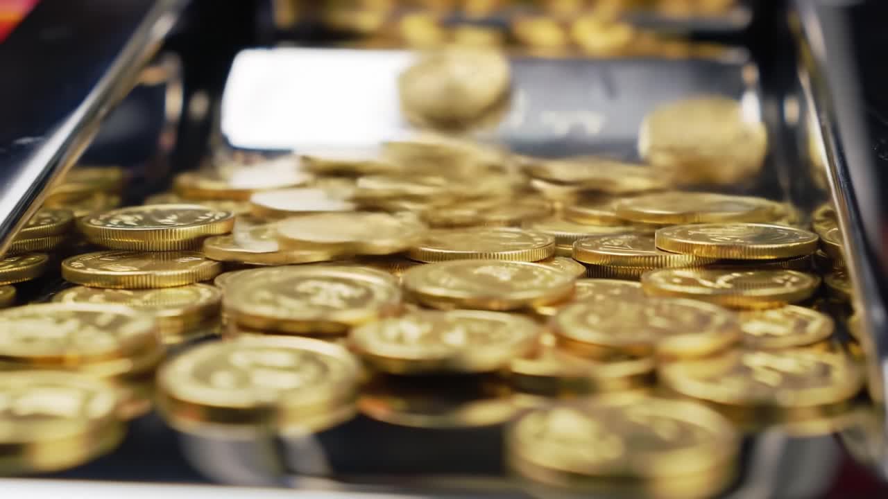 A Gleaming Flow of Coins Cascades Into a Shiny Collector Tray, Showcasing the Rich Details and Luster of Each Coin's Surface in Close-Up Perspective
