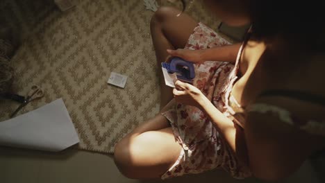 una mujer india graciosa usa delicadamente un puñetazo de oficina para hacer agujeros en las notas, capturada en una hipnotizante cámara lenta de arriba