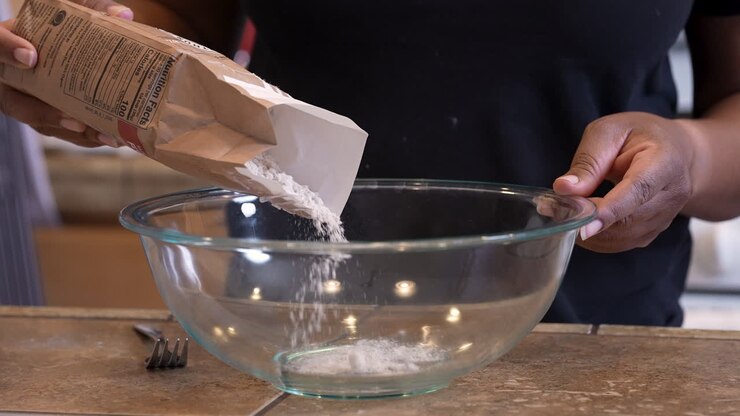 Aggiunta di farina in una ciotola per preparare il pane di Pasqua ebraica - rallentatore