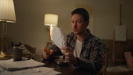man burning papers at home