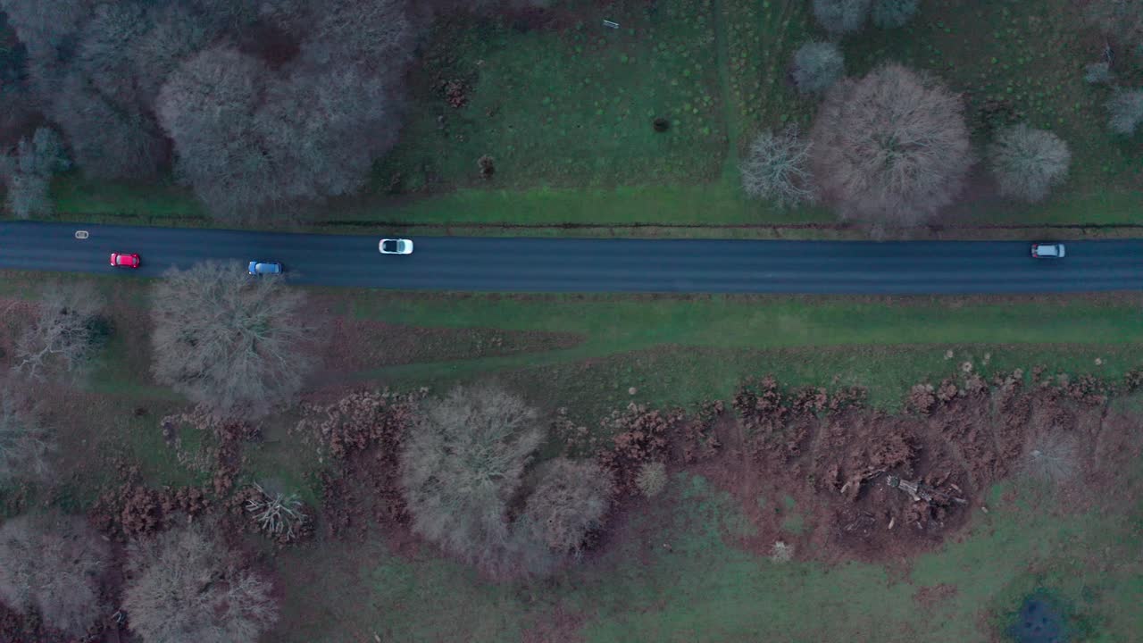 런던 리치몬드 파크의 주요 도로에서 자동차와 자전거의 드론 촬영을 따라