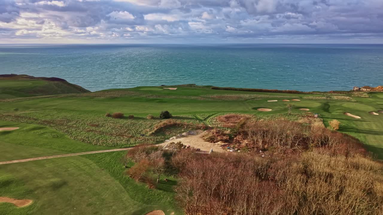 Campo da golf di Étretat sulle spettacolari scogliere della Normandia. La Manica è visibile sotto un cielo nuvoloso, Francia. Vista aerea panoramica da drone