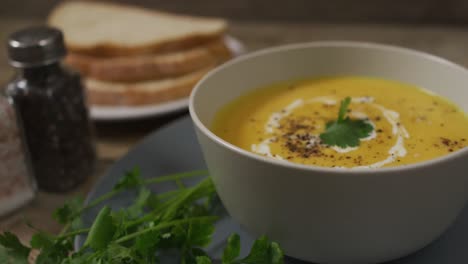 Video-of-cream-vegetable-soup-in-bowl-on-wooden-table-with-decorations