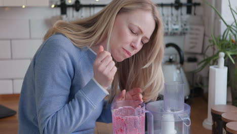 woman making smoothie in kitchen