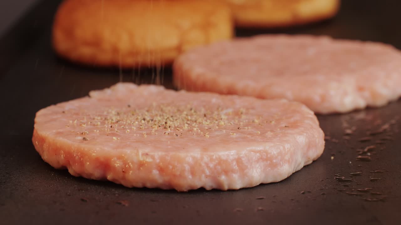 Cooking American fat smash burger on grill close-up. Chiken or fish cutlet smashing by burger press. The chef in kitchen of the restaurant making cutlets for burgers - smash burger beefsteak. Fast and street food concept. High quality 4k footage
