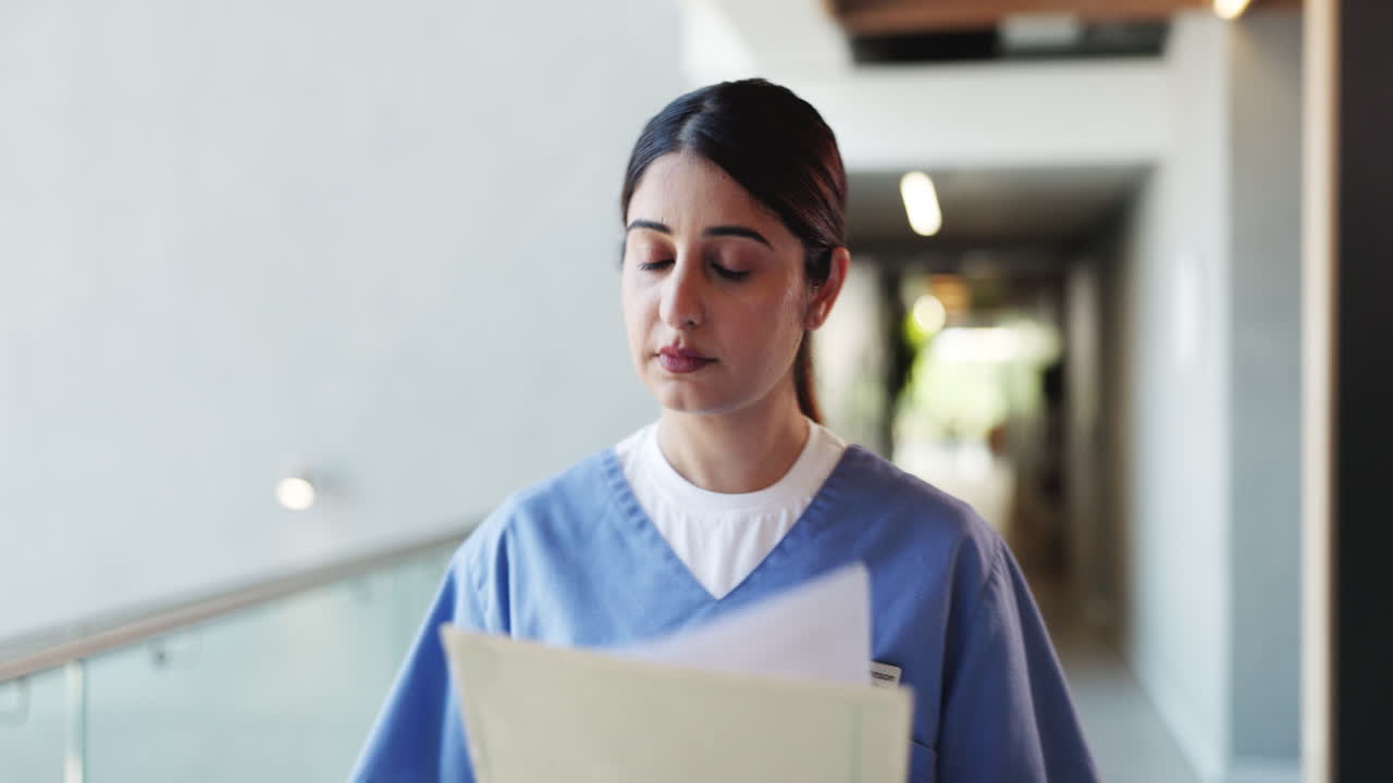 Dottoressa che cammina e revisiona documenti nel corridoio dell'ospedale