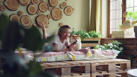 young woman relaxing with dog at home